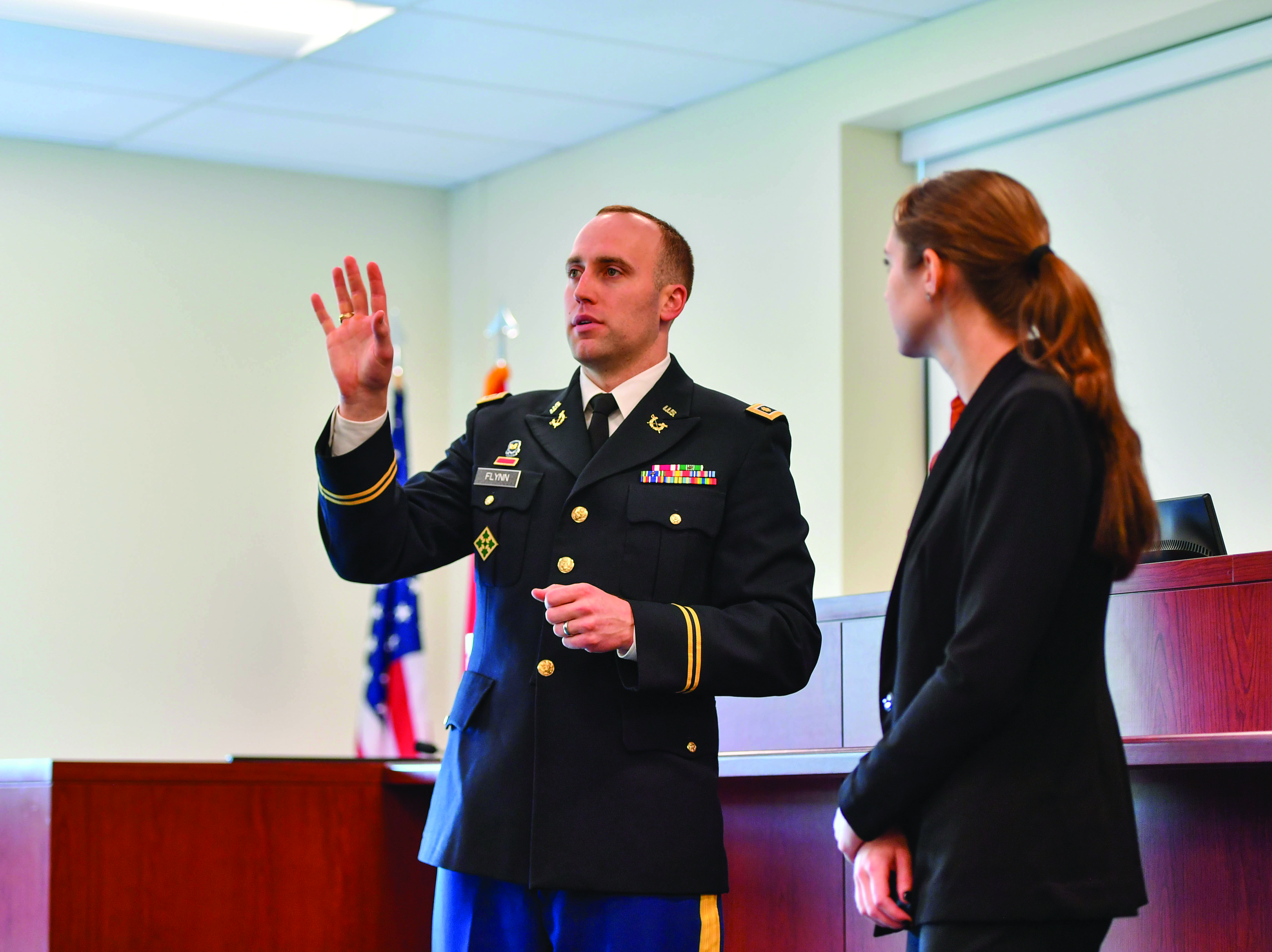 MAJ Sean Flynn speaks to a competitor in the Inaugural BG Wayne E Alley Moot Court Competition in one of the
        U.S. Army Advocacy Center’s courtrooms at Fort Belvoir, VA, on 20 October 2023. (Photo courtesy of author)